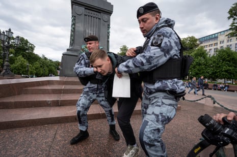 Police officers detain a demonstrator with a poster in support of Alexei Navalny in Pushkin Square in Moscow.