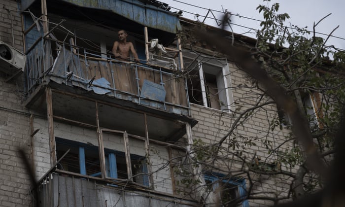 A man stands at the balcony of an apartment in a residential building that was damaged after a Russian attack in Kramatorsk, Ukraine.