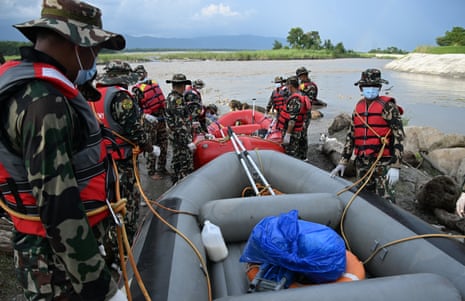 Army personnel preparing to board inflatable boats to search for missing people.