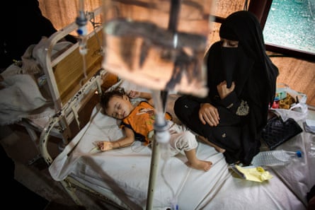 Samira Abdullah watches her daughter Qasima, who is on an IV drip, at a screening tent outside the cholera ward of the al-Sabeen women and children’s hospital.