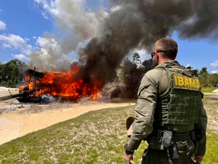 An Ibama agent observes a blaze at a camp