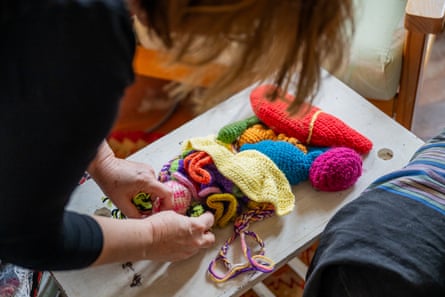 Tracy Sorensen leaning over a human figure showing organs made entirely out of crochet