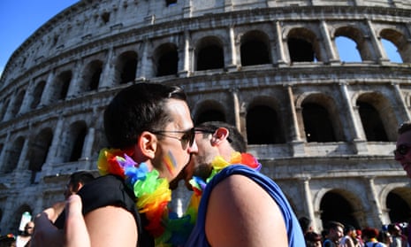 A couple kiss in front of the Coliseum