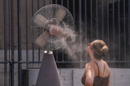 A tourist cools down from a misting fan in Rome.
