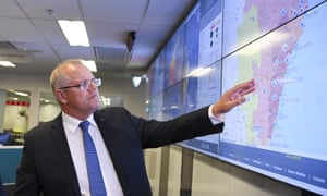 Australian Prime Minister Scott Morrison looks at a screen as he gets a briefing on the bushfire situation in New South Wales and Queensland.
