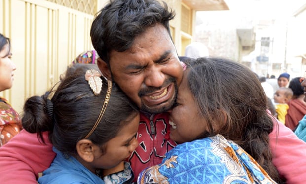A man and children in Lahore at the funeral of a family member killed in the blast.