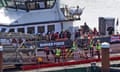 A group of people are brought ashore in Dover, Kent, on Monday