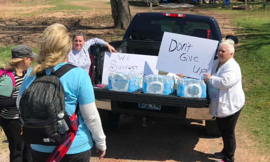 Beverly Langley, right, hands out water and encouragement as Oklahoma teachers march to Oklahoma City.