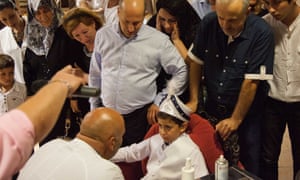 Adults eagerly watch as a scared-looking boy is circumcised in Turkey.