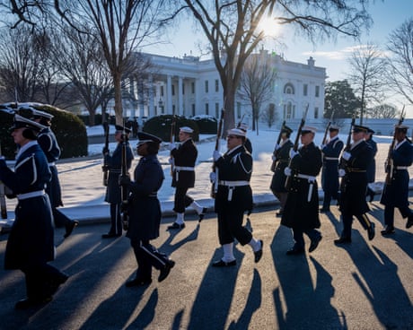 soldiers marching outside by white building