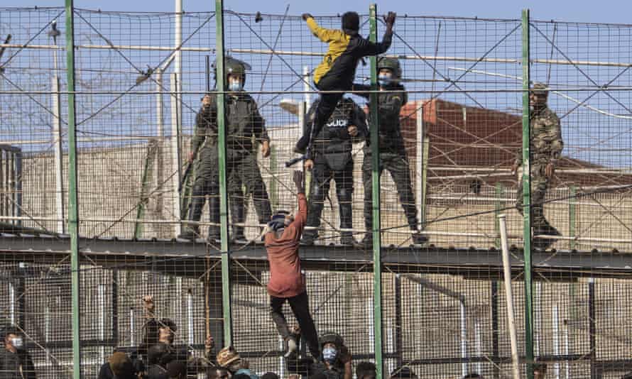 Migrants climbing the fences separating Melilla from Morocco