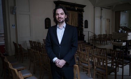 Benjamin Stanley looking at the camera while standing in a synagogue