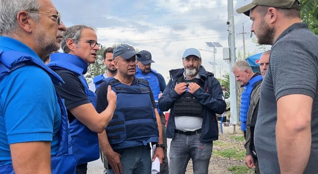 In this photo released by the International Atomic Energy Agency, the Director General of nuclear watchdog, Rafael Mariano Grossi, second from left, speaks to unidentified authorities as the UN agency mission heads to the Zaporizhzhia nuclear power plant.