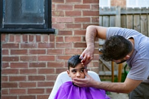 Mustapha gets a post-lockdown trim from a mobile barber in the back garden of their home