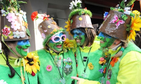 A group of four paraders, dressed in green and lemon outfits with plant pots on their heads at the Dunkirk carnival, France.