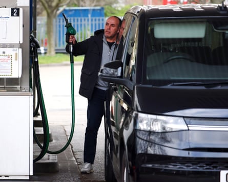 A customer fills his tank at a petrol station in London