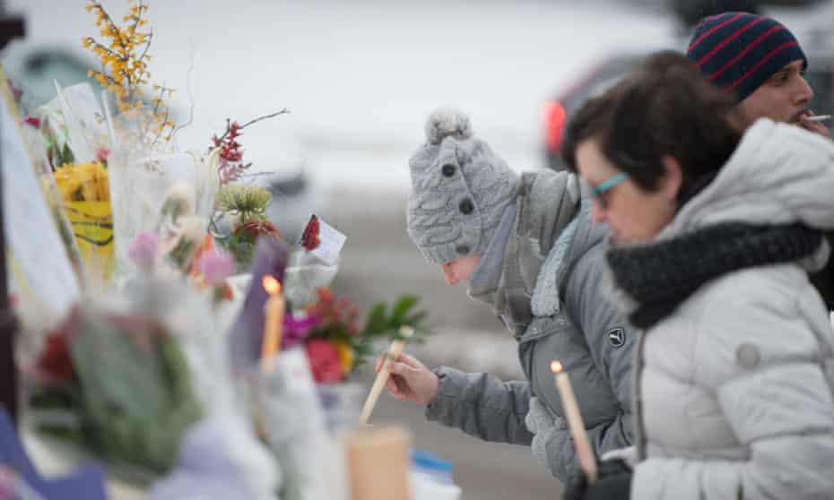 People visit a makeshift memorial near a mosque that was attacked in Quebec City, Canada on 30 January, 2017.