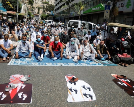Protests against UAE’s deal with Israel to normalise relations<br>Palestinian sit as cutouts depicting U.S. President Donald Trump and Abu Dhabi Crown Prince Mohammed bin Zayed al-Nahyan and Israeli Prime Minister Benjamin Netanyahu are seen on the ground during a protest against the United Arab Emirates’ deal with Israel to normalise relations, in Nablus in the Israeli-occupied West Bank August 14, 2020. REUTERS/Raneen Sawafta