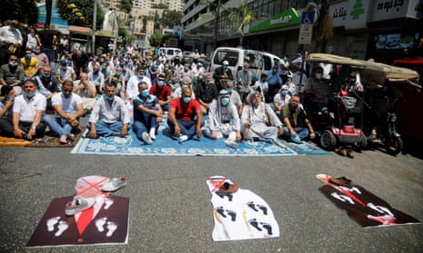 Palestinians protest with cutouts depicting Donald Trump, Mohammed bin Zayed Al Nahyan and Benjamin Netanyahu, in the West Bank, 14 August 2020. 