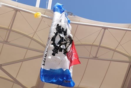A parachutist delivering the match ball hangs from the stand at Stadium de Toulouse