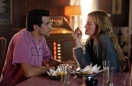 A man and a woman sits in a bar looking into each other’s eyes