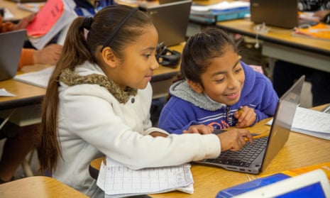 Hispanic third grade students enter information in their Google Chromebook laptop computers in a San Clemente elementary school classroom.
