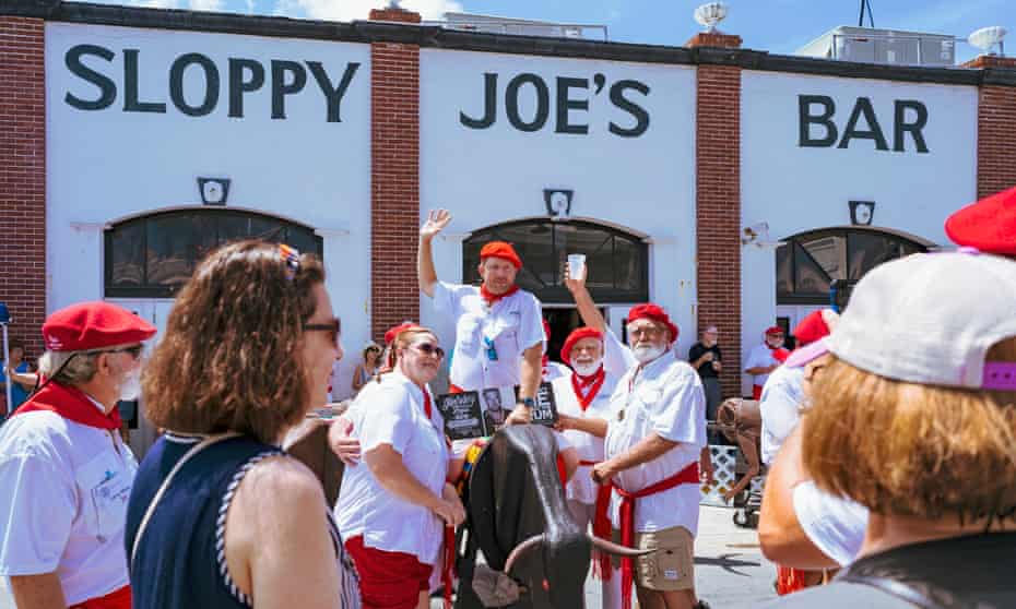 People take pictures with participants of the Hemingway look-a-like contest