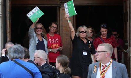 Women hold up copies of the report after leaving the hall.