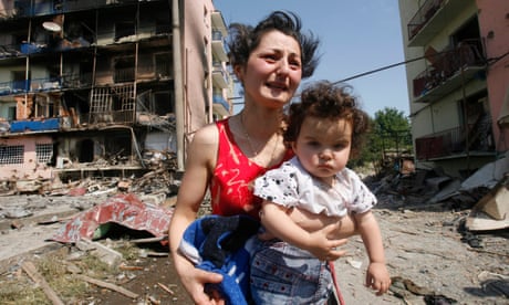 A woman holds her baby outside her destroyed home in Gori after Russia’s invasion of Georgia in 2008.