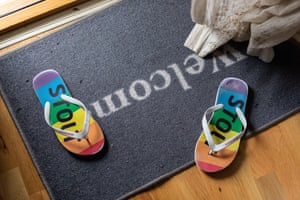 Flipflops በኩራት ቀለሞች በአቀባበል ምንጣፍ ላይ