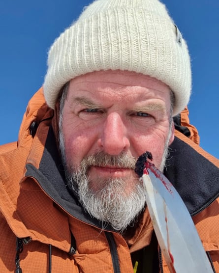 Portrait of Mike Keen holding a knife with a bit of blood on the tip