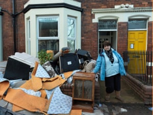A resident of Warwick Road stands by her belongings that have been ruined by the floods, 11 December 2015
