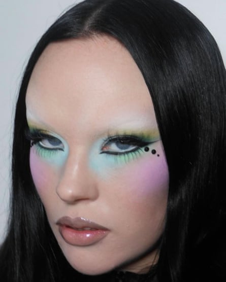 A model with vivid turquoise, pink and black makeup