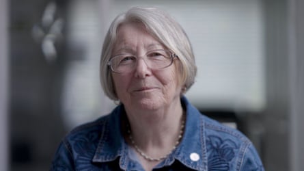 Head and shoulders shot of a woman wearing glasses and a blue denim top
