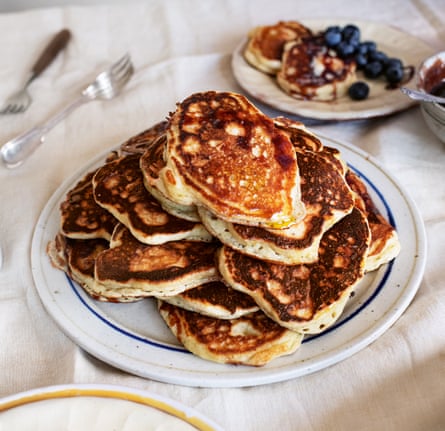 Pancakes piled on a plate with white tablecloth background