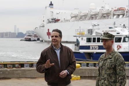 Andrew Cuomo, left, gestures during a brief news conference as he stands beside a Rear Adm. John B. Mustin as the USNS Comfort, a naval hospital ship with a 1,000 bed-capacity, pulls into Pier 90 Monday, March 30, 2020, in New York.