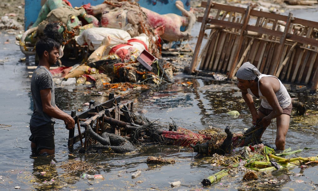 Indian workers remove religious offerings from the Yamuna river in Delhi. Photograph: Money Sharma/AFP/Getty