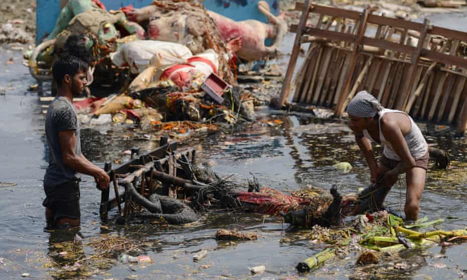 Indian workers remove religious offerings from the Yamuna river in Delhi.