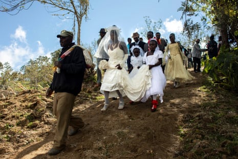 Father of the bride Merilus Bonheur, who works as a forest ranger, leads his daughter Christela Bonheur, 29, and their relatives to church on the day of Christela’s wedding to Jocithe Auguste, in Foret des Pins, Zone Mare Rouge