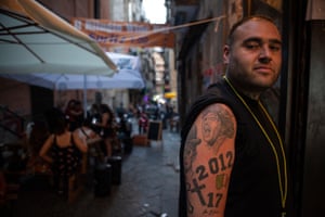 The owner of a wine bar in a Quartieri Spagnoli alley displays tattoos of Maradona and Totò on his arm. A labyrinth of narrow streets, tall 16th-century buildings and balconies, originally built to house Spanish garrisons, the district is the beating heart of Naples. In recent years it has become a destination for tourists fascinated by its crumbling buildings and authetic character
