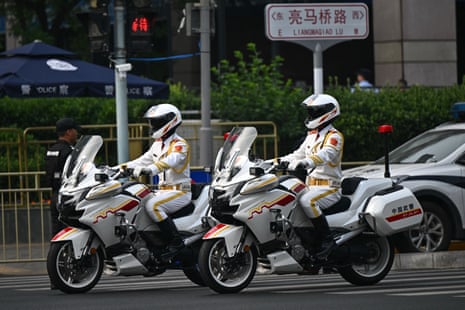 Motor unit police officers ride around the perimeter of the hotel where Donald Trump is staying in Beijing.