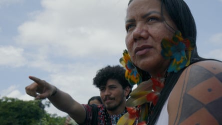 Village leader Miriam Tembé, with feather earrings, looks on as Josias Dias dos Santos points ahead