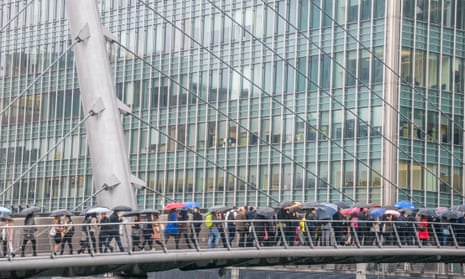 Commuters walking across a bridge in Canary Wharf, London.