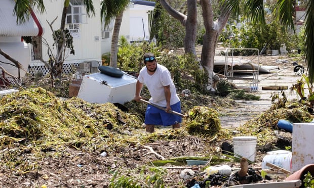 A man shovels seagrass from the entrance of his mobile home in the wake of Hurricane Irma at Tavernier Key, Florida.