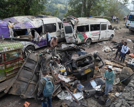 People look at damaged vehicles