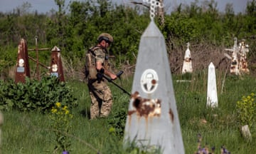 A Ukrainian soldier demines the cemetery on the site of heavy battles with the Russian troops in the village of Krasnopillya, Donetsk