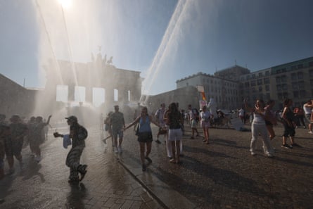 People walk among water spray near the Brandenburg Gate