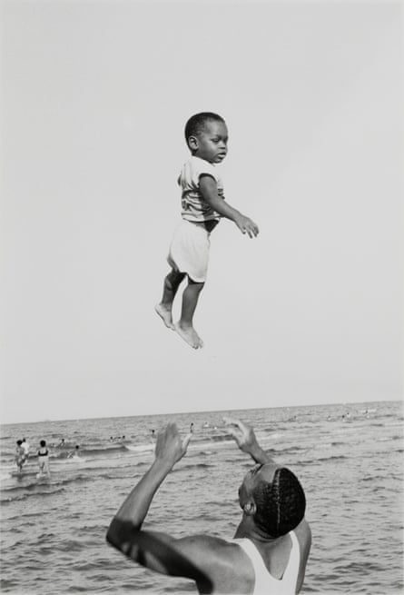a black and white image of a young boy being thrown in the air