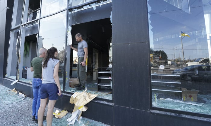 Shop owners inspect broken windows in downtown Kharkiv after the Russian rocket attack