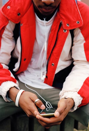 A young man holding a phone, face out of shot